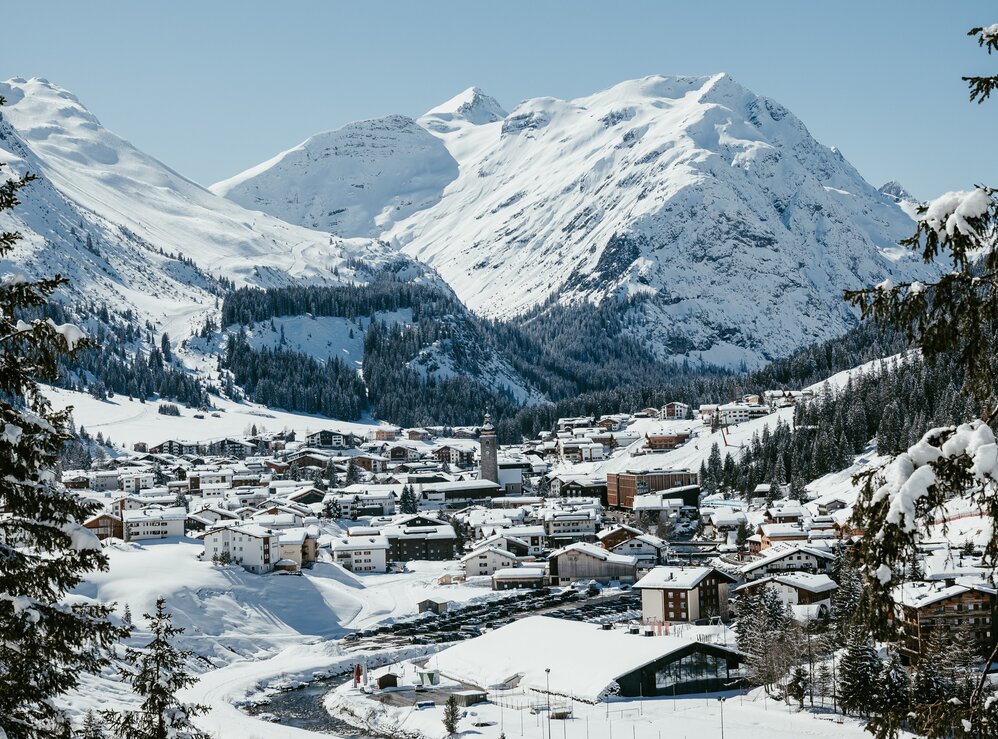 Das schneebedeckte Lech Zürs umgeben von hohen, verschneiten Bergen.