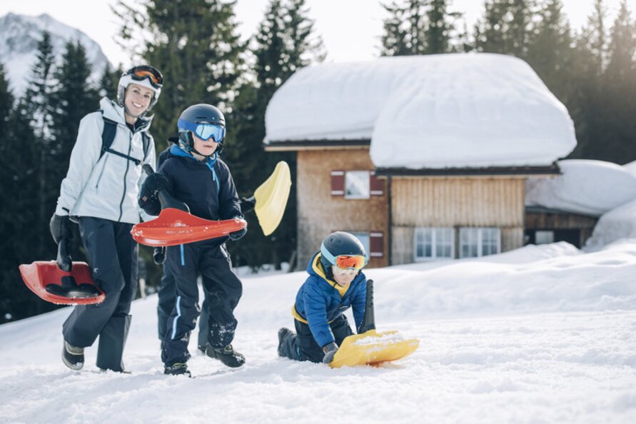 Familie auf dem Weg zur Rodelbahn in Lech Zürs