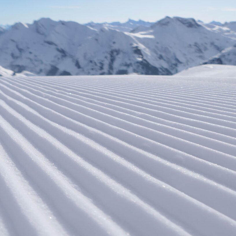 A perfectly groomed slope at Lech Zürs ski resort with mountain panorama in the background.