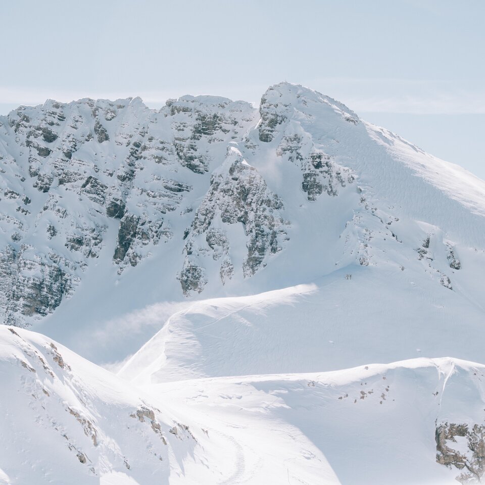 Verschneiter Berg mit felsigen Gipfeln, sonniger Tag