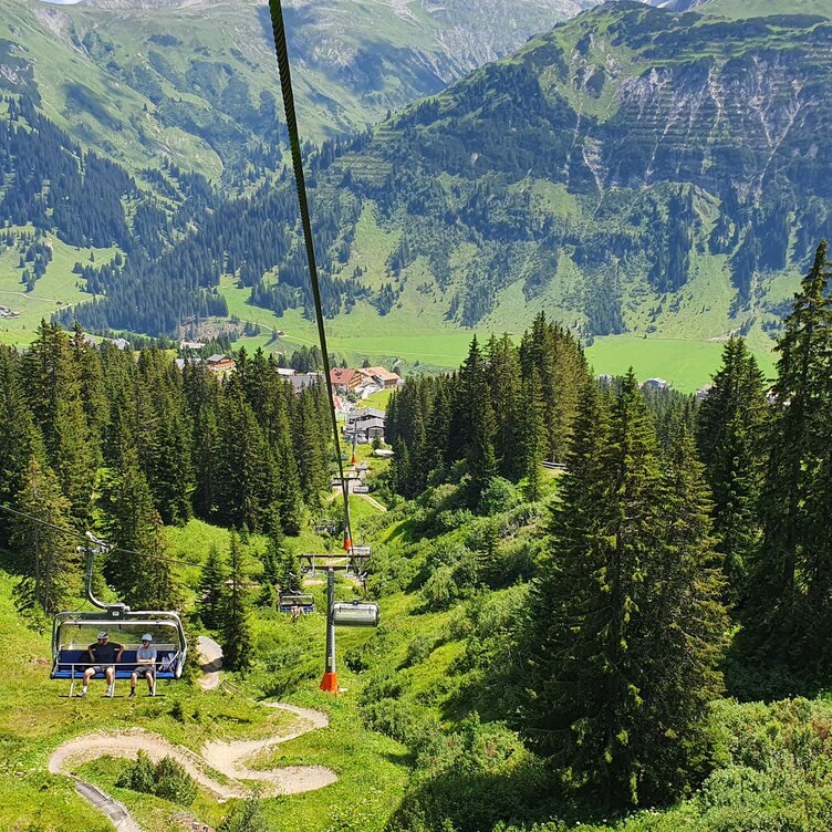 Blick auf eine Seilbahn und grüne Berglandschaft am Familienberg Kriegerhorn.