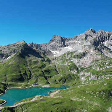 Klarer Zürsersee eingebettet zwischen grünen Berghängen am Naturberg Seekopf.