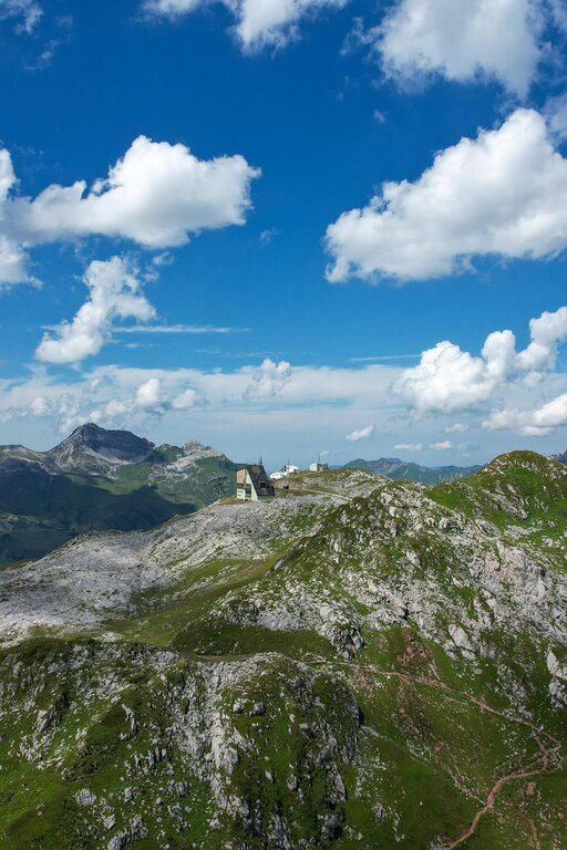 Grüne und felsige Berglandschaft unter blauem Himmel des Panoramarbergs Rüfikopf.