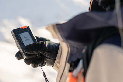 Eine junge Teilnehmerin der Mammut Safety Roadshow hält ein LVS in der Hand.