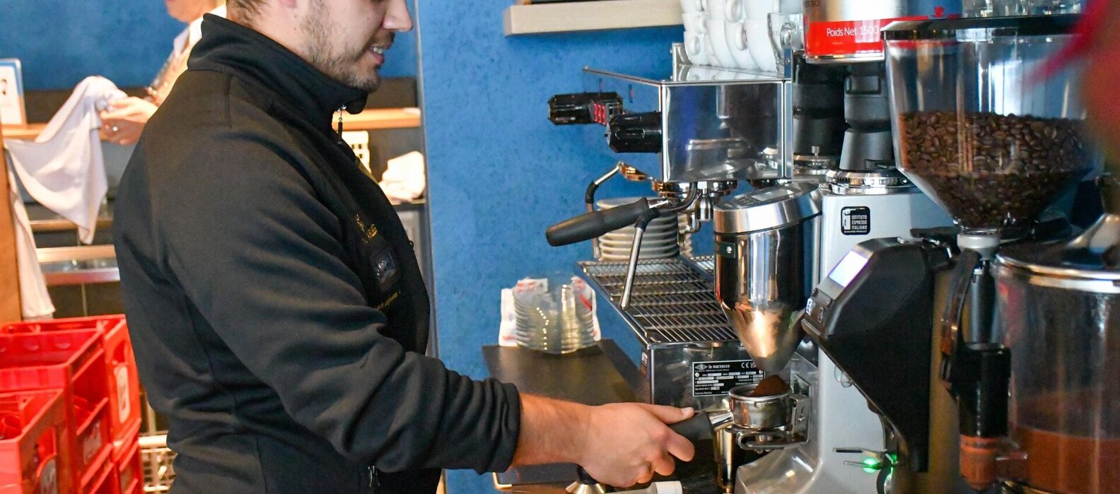 Ein Barista bereitet im Bistro Mila Kaffee zu.