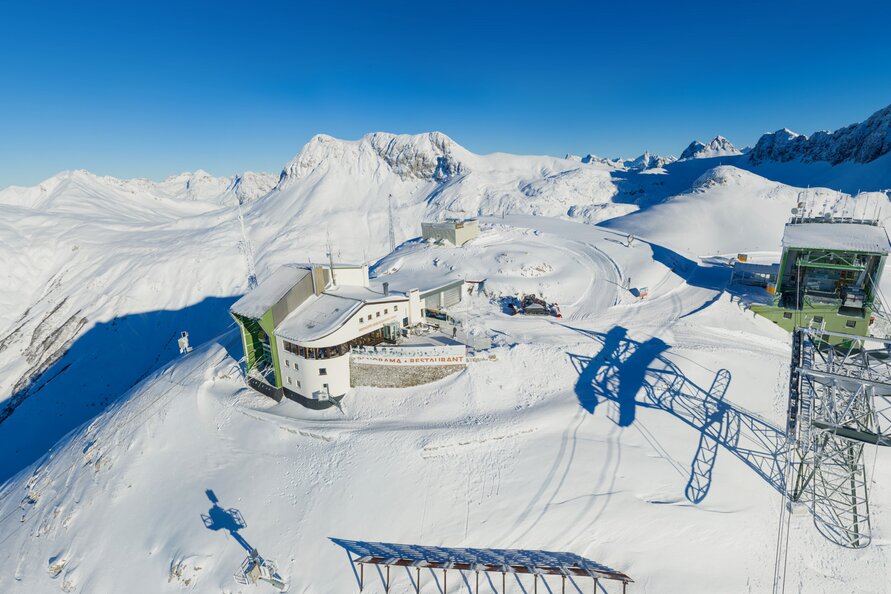 Panoramablick auf das verschneite Rüfikopf Restaurant in den Alpen.
