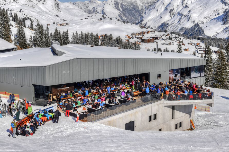 Skifahrer genießen Mittagspause auf der Terrasse des am Schlegelkopf Restaurants.