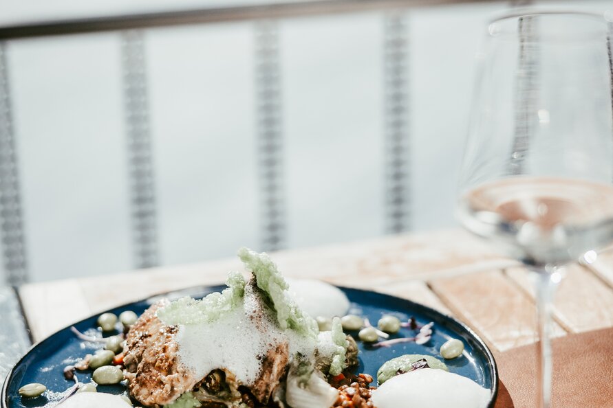 Fein angerichtetes Gericht mit Schaum, Nüssen und Sauce im Schlegelkopf Restaurant.