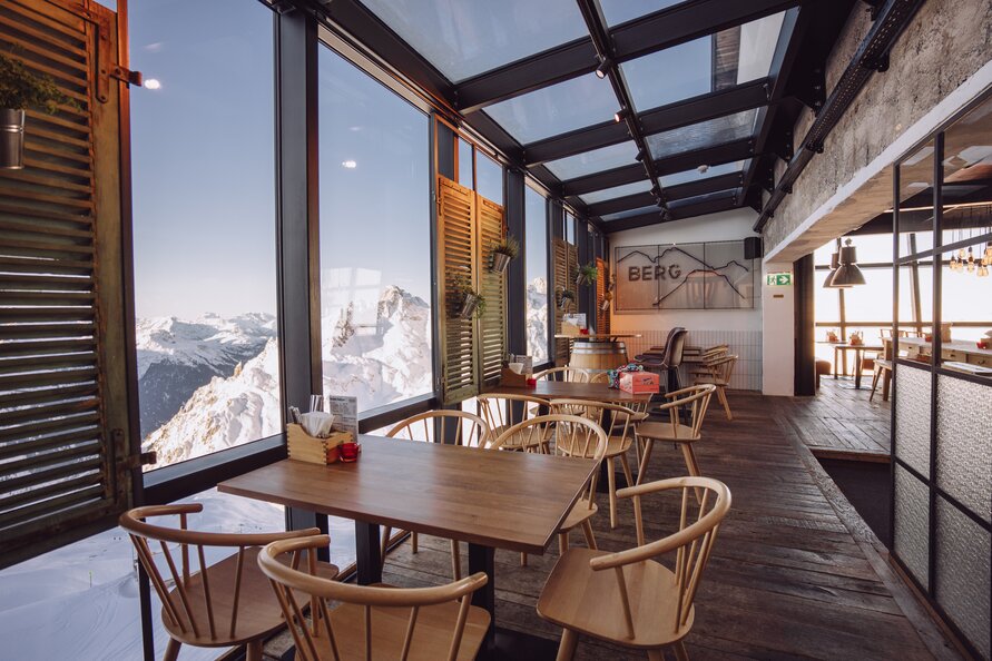 Große Panoramafenster im Innenbereich der Trittkopf BBQ Station ermöglichen beeindruckenden Blick auf die Berglandschaft.