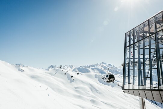 Verschneite Berglandschaft mit Skilift und Seilbahn.