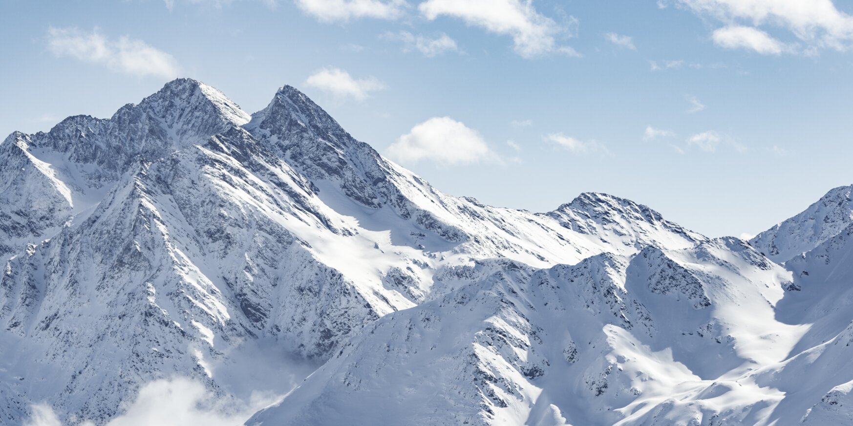 Eine beeindruckende Ansicht schneebedeckter Berge unter blauem Himmel.