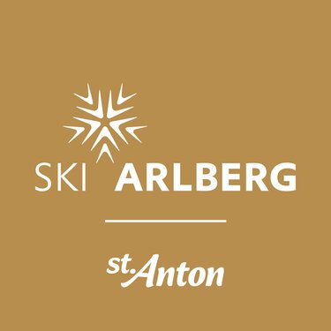 Das Logo von Ski Arlberg in St. Anton auf braunem Hintergrund.