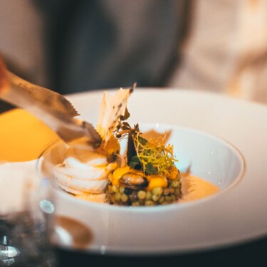 Eine elegant angerichtete Speise mit feinen Details in einem stilvollen Restaurant serviert.