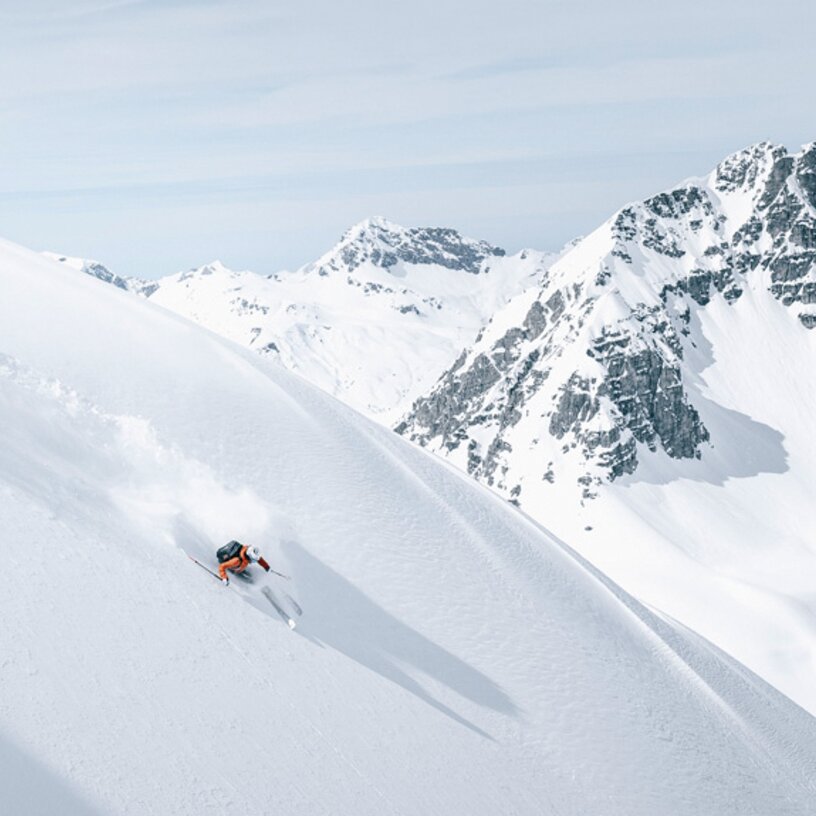 Person fährt auf verschneitem Hang in Skiregion St. Anton am Arlberg.