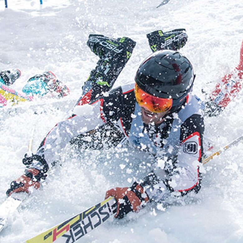 Drei Skifahrer fallen im Skirennen 'Der Weisse Rausch' auf der schneebedeckten Piste hin.