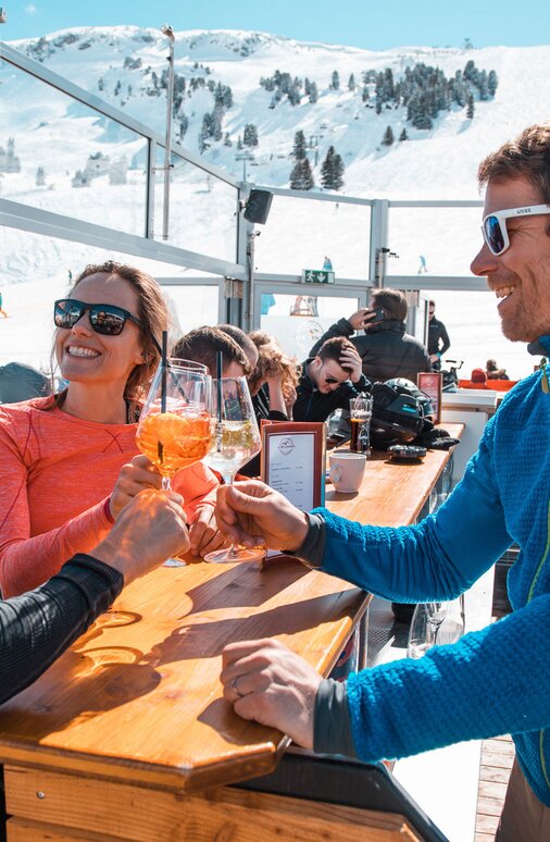 Personen genießen Drinks in der S1 Skilounge mit Bergblick.