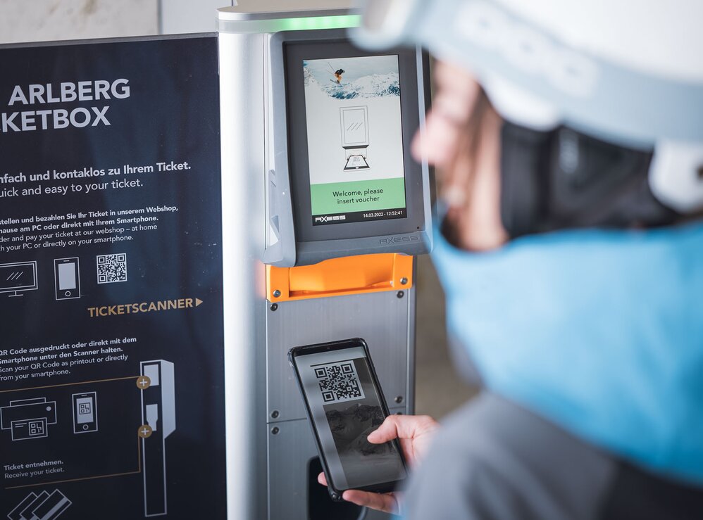 Person scannt QR-Code an einem Ski Arlberg Ticketautomaten.